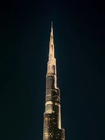 The illuminated spire of the Burj Khalifa piercing the night sky.