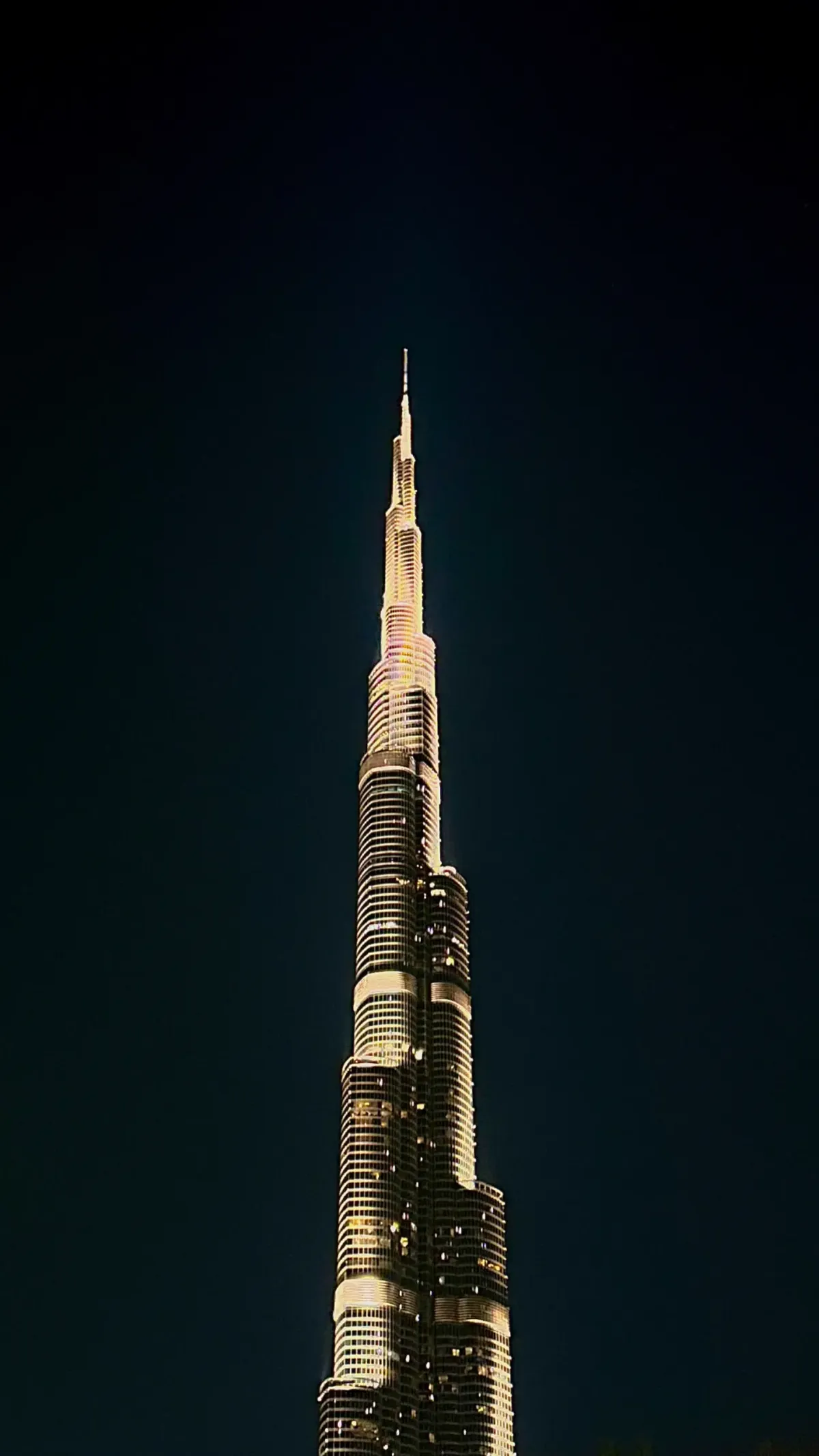 The illuminated spire of the Burj Khalifa piercing the night sky.