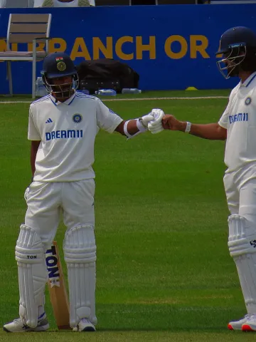 KL Rahul and Abhimanyu Easwaran fist-bump mid-pitch during a partnership at the Northampton County Cricket ground.