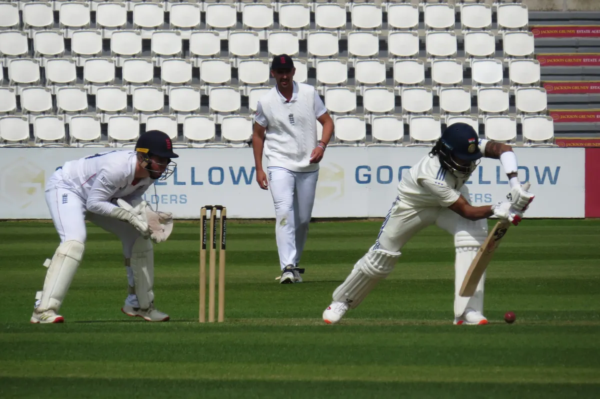 KL Rahul plays a defensive shot as the England wicketkeeper and fielder look on.
