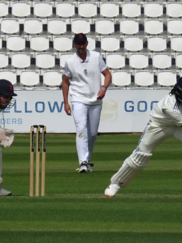 KL Rahul plays a defensive shot as the England wicketkeeper and fielder look on.