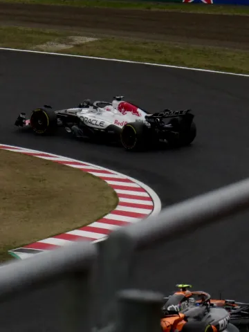 Max Verstappen in the Red Bull being chased down by McLaren's Lando Norris for the lead during the 2025 Japanese Grand Prix.