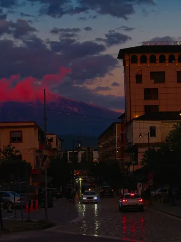 Mount Tomorr glows red at dusk above the streets of Berat, Albania.