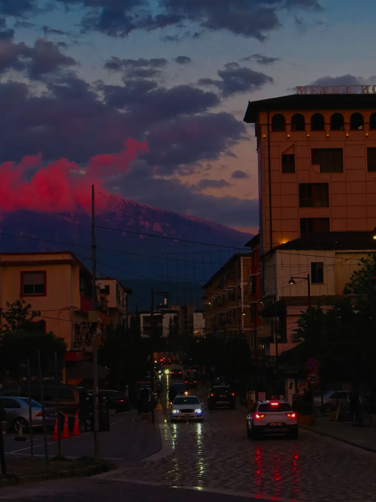 Mount Tomorr glows red at dusk above the streets of Berat, Albania.
